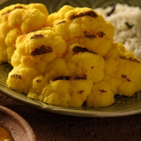 Roasted cauliflower florets with char marks and curry.
