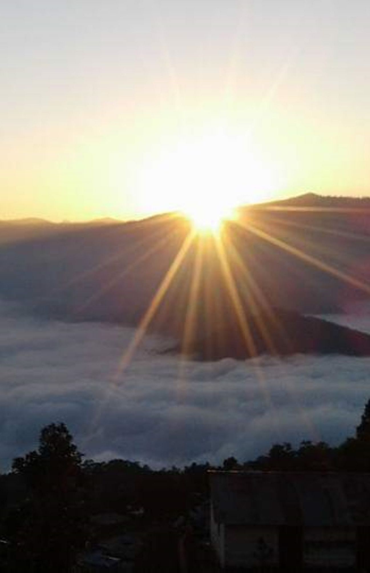 Image of a sun rising behind a mountain range