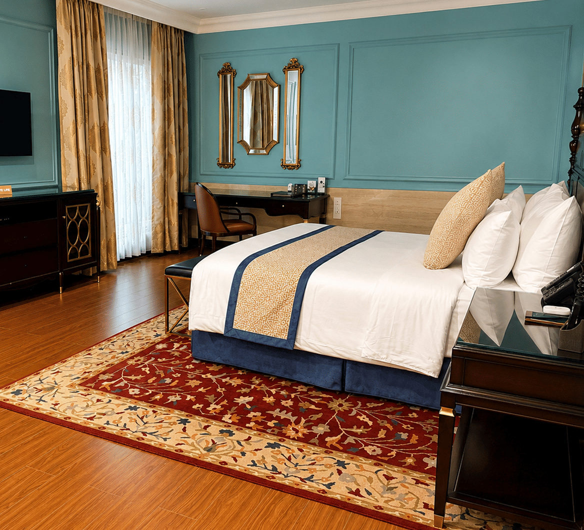 Junior Suite bedroom with teal accent walls and wooden flooring at MAYFAIR Lake Resort, Raipur