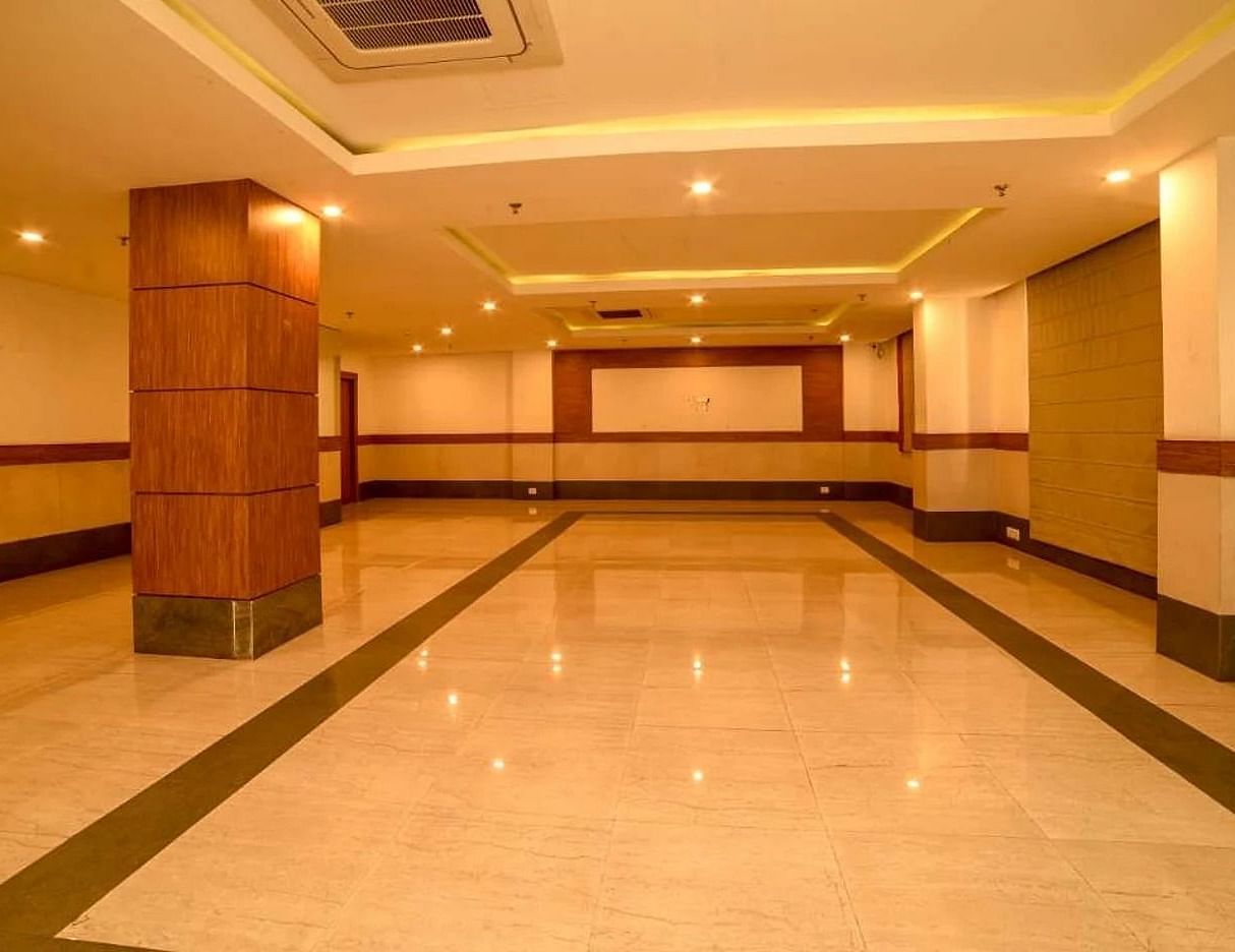 full view image of the spacious banquet hall with white tile flooring - Max Hotel, Jabalpur