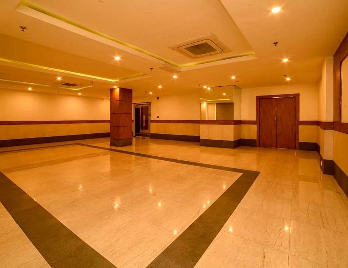 a wide angle shot of our banquet hall with warm lights installed in the false ceiling with central air-conditioning - Max Hotel, Jabalpur