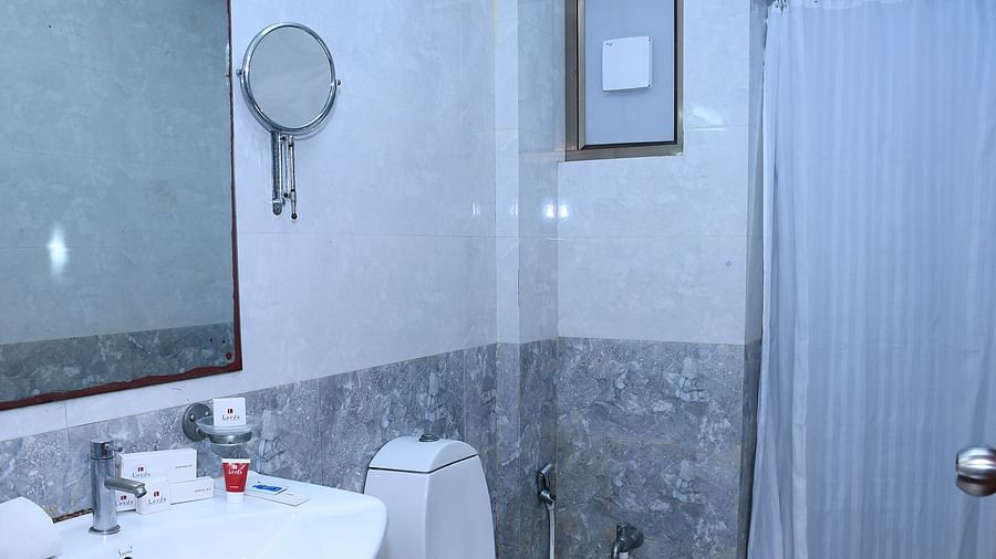 Bathroom with a sink, toilet, mirror, and shower area with curtain