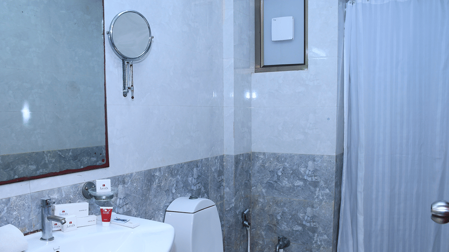 Bathroom with a sink, toilet, mirror, and shower area with curtain