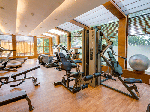 An interior view of Pulse Gym with numerous gym equipment items, a floor to ceiling window on all sides and premium lighting on the ceiling at at Pulse Gym inside Kenilworth Hotel, Kolkata.