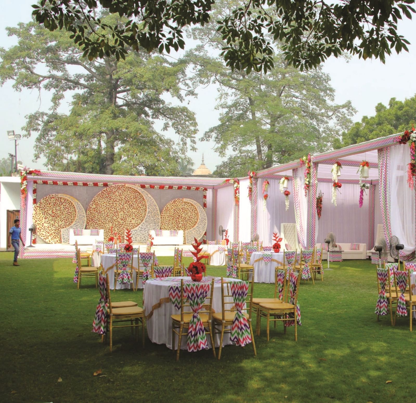 An outdoor banquet setup with round tables and floral decor at Gemini Continental, a hotel near lucknow railway station