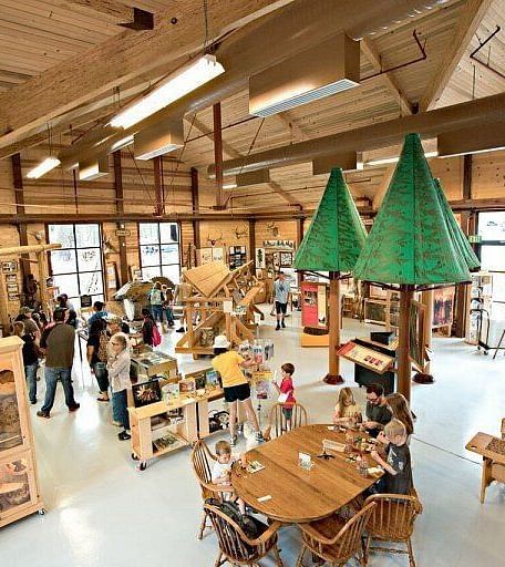 Interiors of a museum with large wooden beams and a sloping roof line - Shaver Lake Village Hotel.
