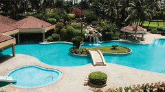 Aerial view of The Retreat Hotel and Convention Centre highlighting the outdoor swimming pool, poolside seating, palm trees and the resort-style layout of the property.