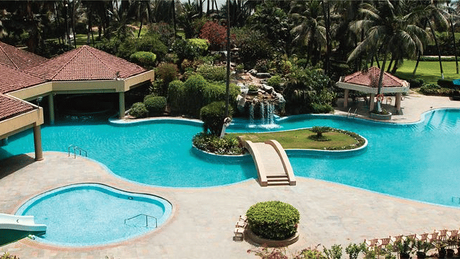 Aerial view of The Retreat Hotel and Convention Centre highlighting the outdoor swimming pool, poolside seating, palm trees and the resort-style layout of the property.