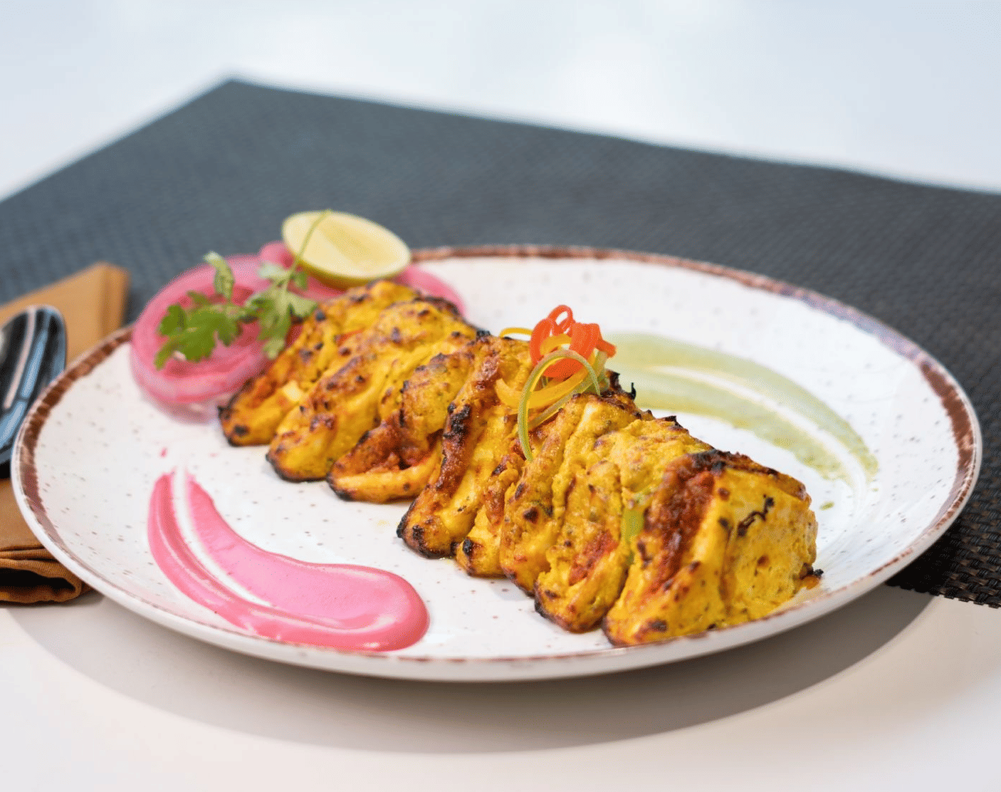 A plate of golden-brown appetisers with a sauce and garnish, stating Happiness served on a plate! at Cenneys Gateway.