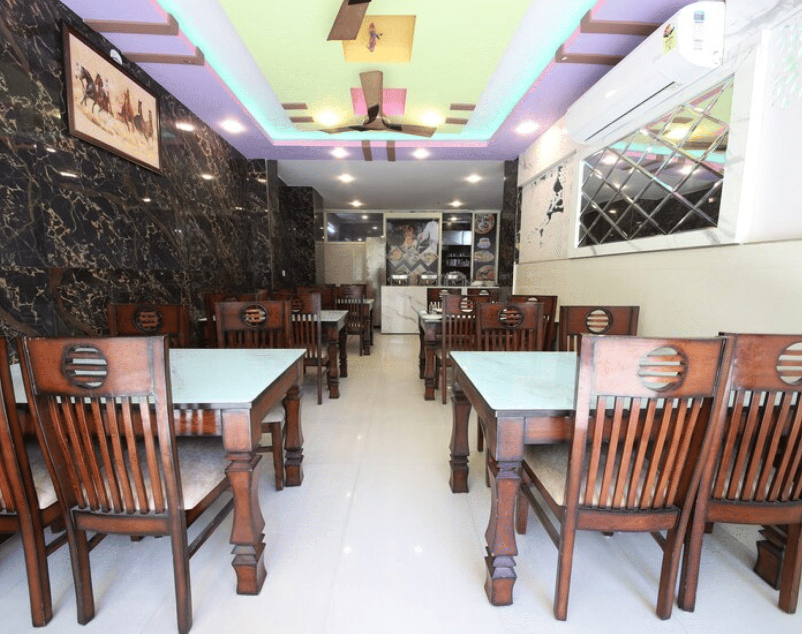 A dining area with neatly arranged wooden chairs around square dining tables | Perfectstayz Value Hills, Rishikesh