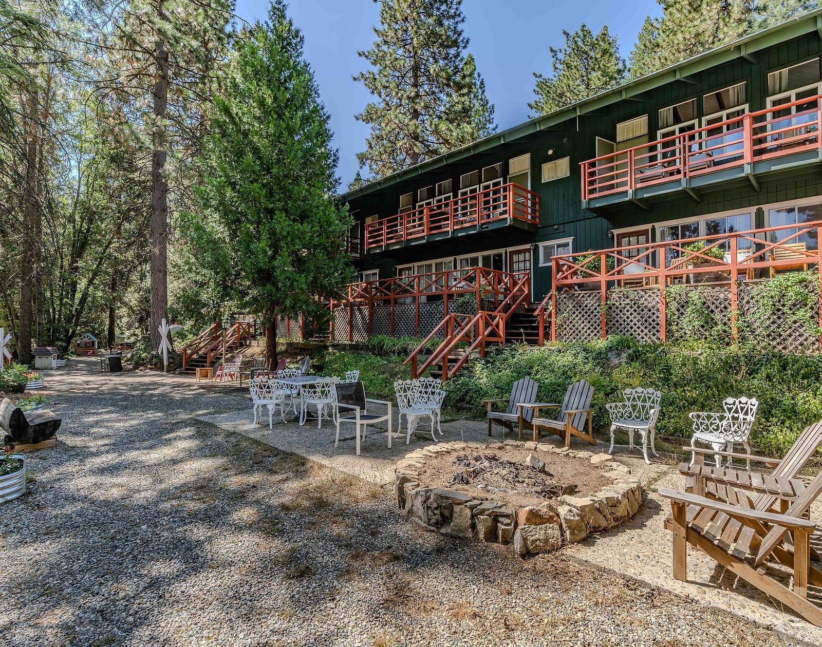 Outdoor seating in front of the cabin at Narrow Gauge Inn surrounded by trees.