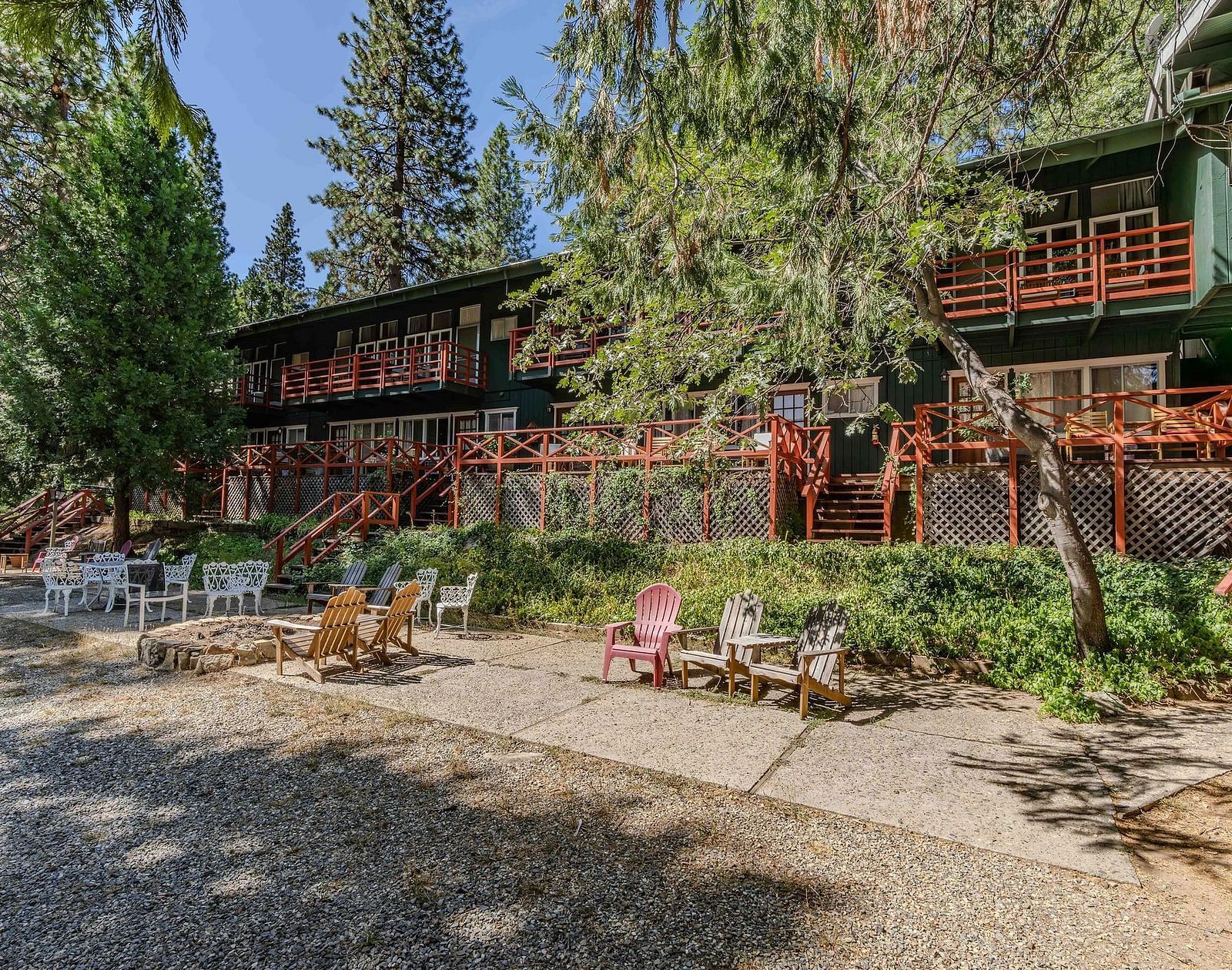 Seating in front of the facades of cabins with forest green exteriors at Narrow Gauge Inn.