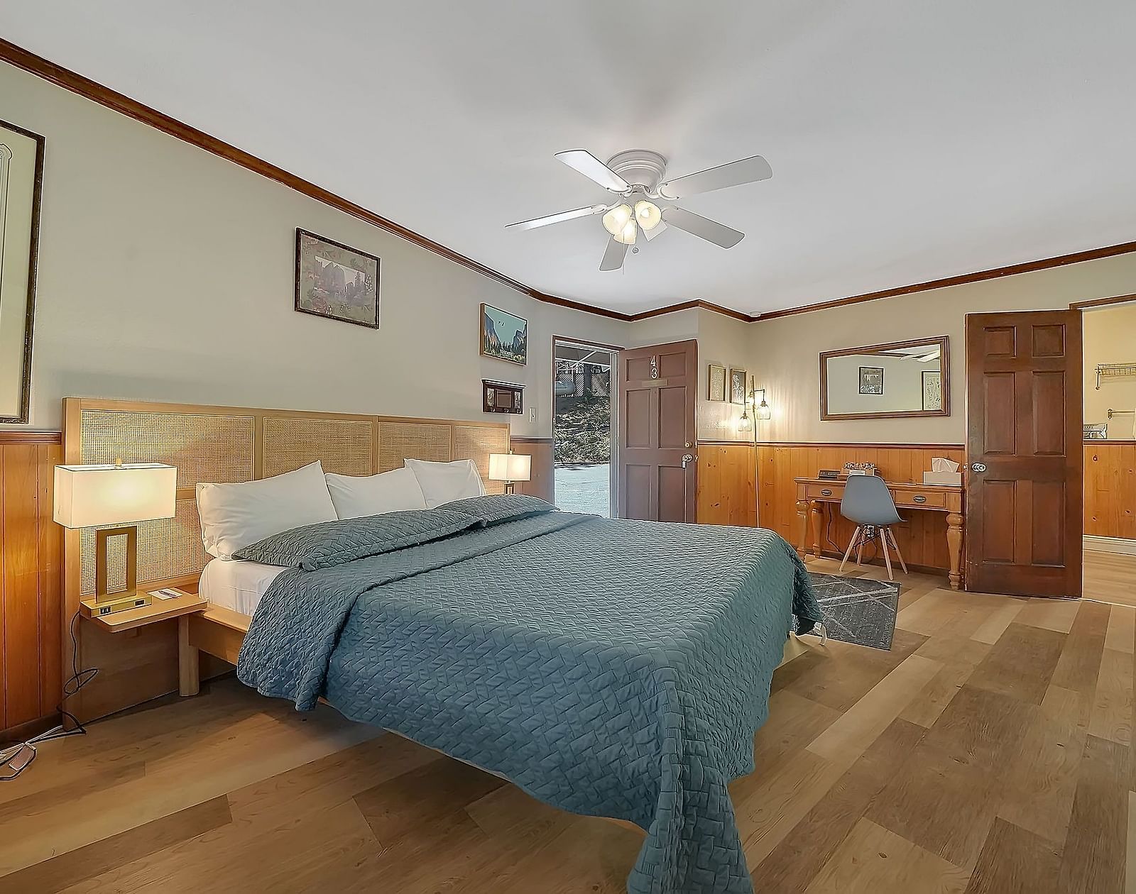 A view of a room at Narrow Gauge Inn with a double bed and side tables with table lamps.