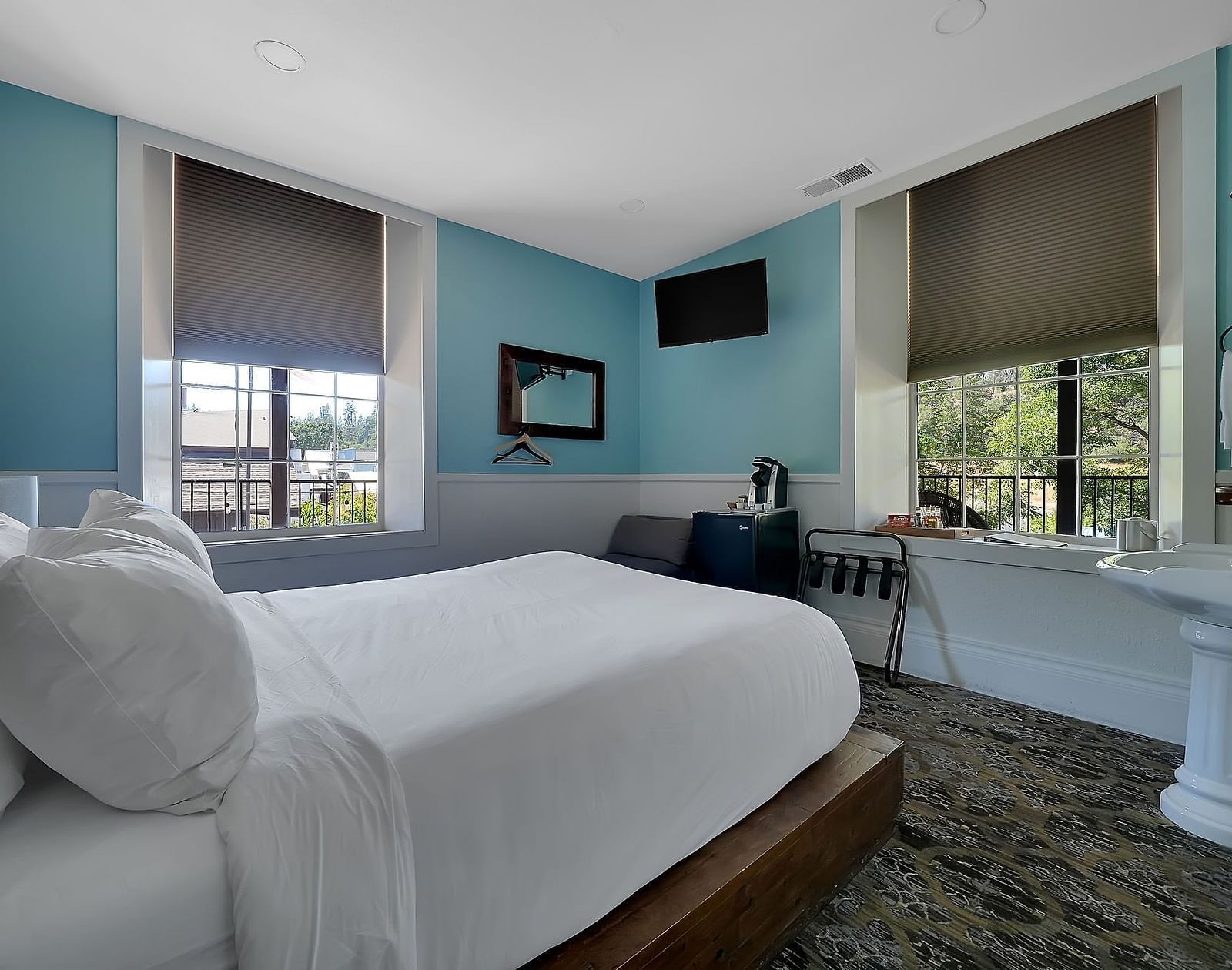 Overview of a pastel coloured room at The Groveland Hotel with a double bed and table.