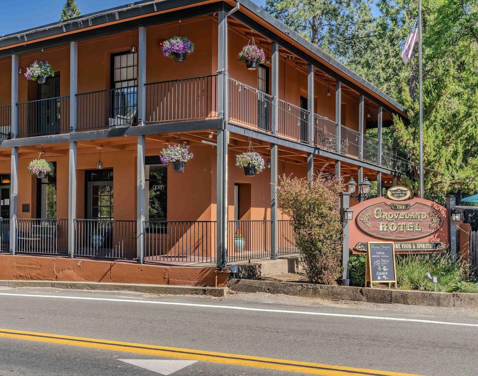 Exterior of a cabin at The Groveland Hotel during the day with the hotel's signage in view.