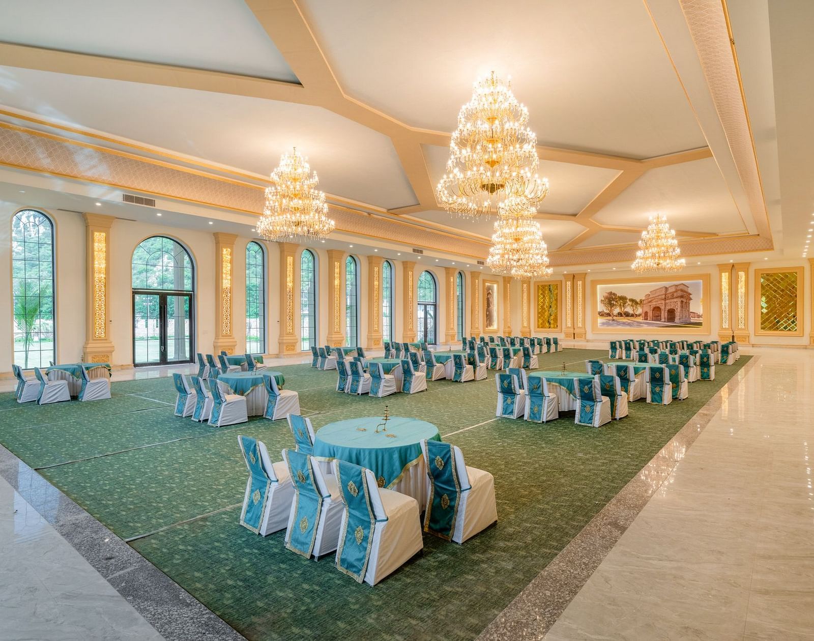 Back view of a banquet hall at Valley by Grassfield, showcasing a well-arranged table and chair setup with large windows on the side.