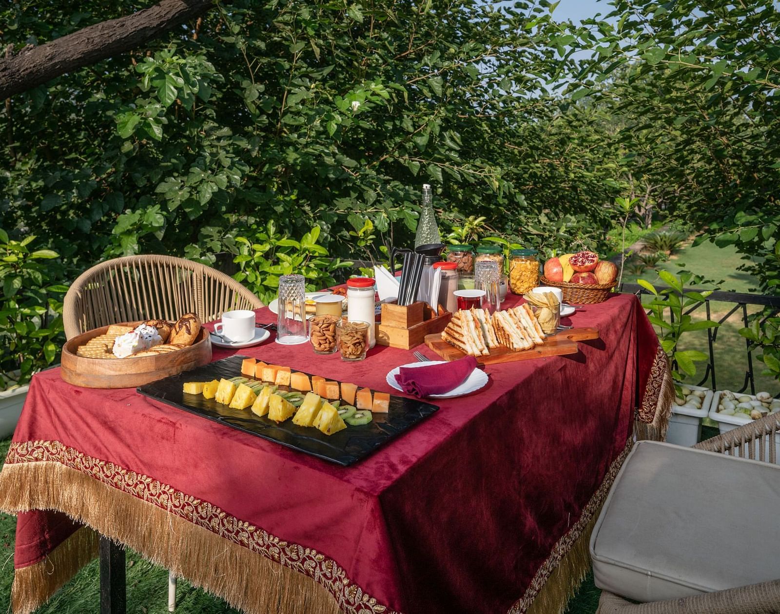 A table filled with food set in an outdoor space surrounded by lush plants at Valley by Grassfield.