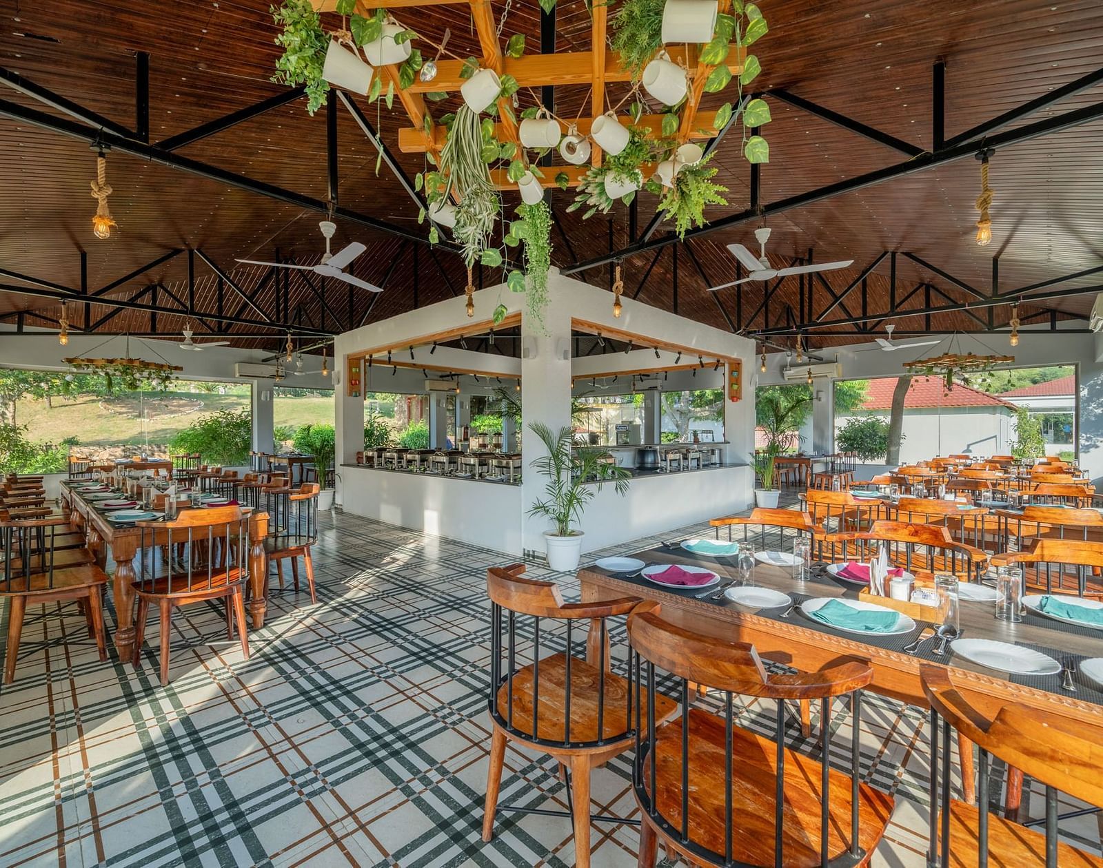 A dining area with wooden tables and chairs, complemented by ceiling fans at Valley by Grassfield. 