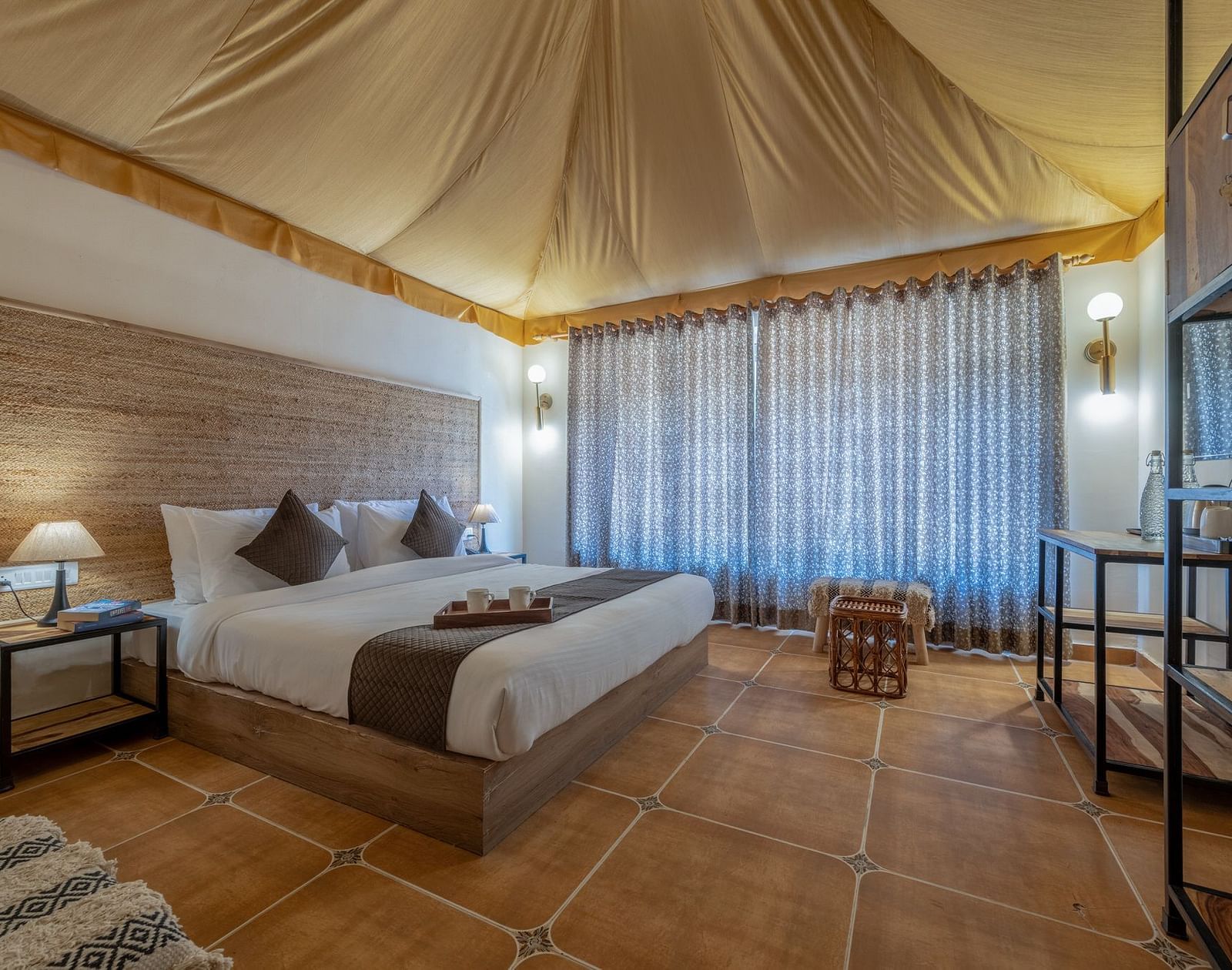 A tent accommodation at Valley by Grassfield with a bed and a side table.