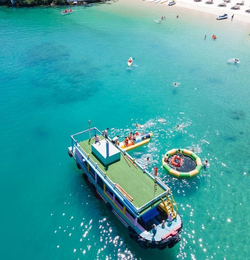 A colourful floating water park on the sea with inflatables, perfect for fun-filled water activities near Alibu Resort.