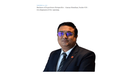 Formal headshot portrait of Kumar Roushan, Senior GM – Development & Pre-opening, wearing a dark suit, tie, and glasses.