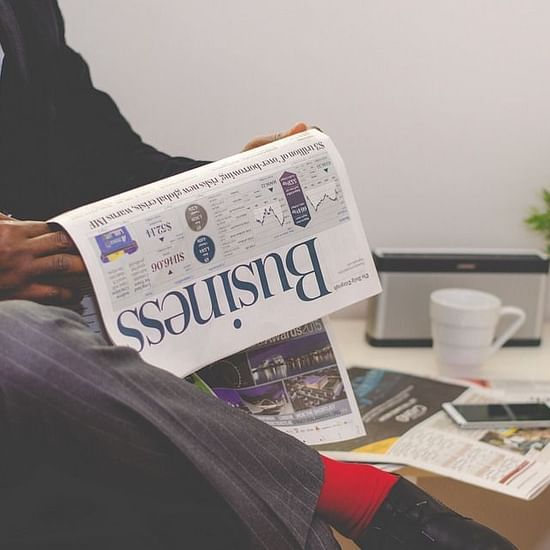 a person reading the business newspaper
