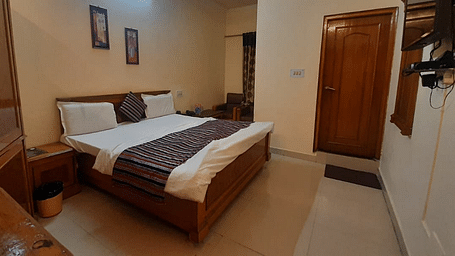 An image of a room in Roorkee with a king size bed, a cupboard and a television - Motel Divine International, Roorkee