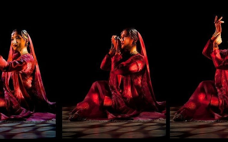 Three women performing a dance on a stage with spot lighting on them and a black backdrop