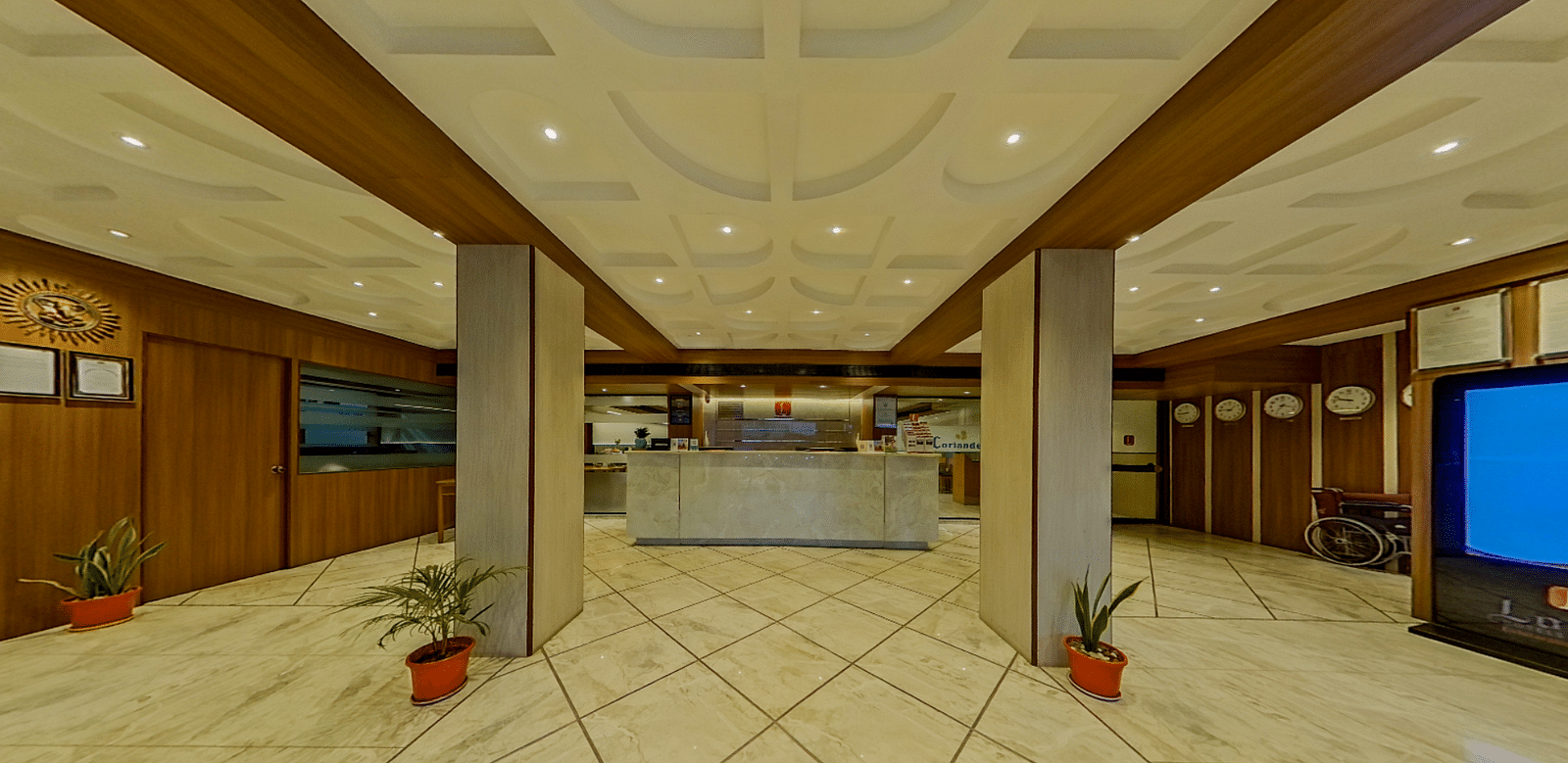 Elegant hotel lobby with marble floors, ornate ceiling and wooden panels at Lords Eco Inn Dahej, creating a welcoming entrance for guests.