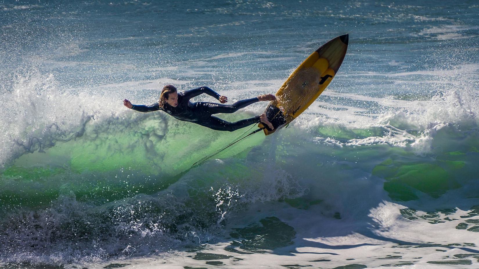 image of a man surfing through the ocean waves