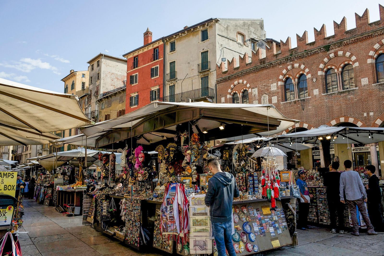 image of a street shop selling souvenirs to tourists along with other shops around it  