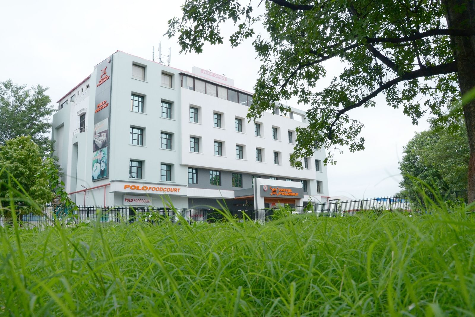 Facade view of Max Hotel Prayagraj surrounded by greenery.