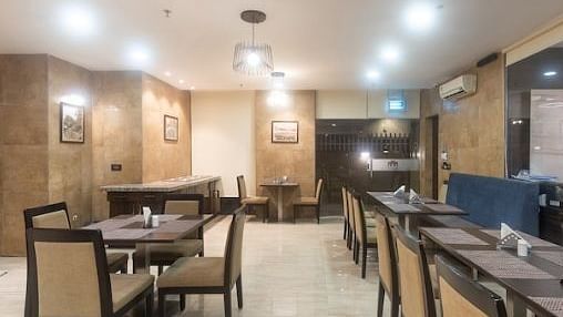 Chairs and round tables at a restaurant | Hotel Mumbai House, Andheri East
