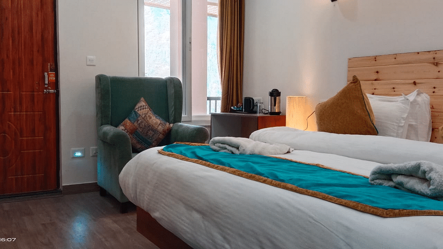 Double Bed Premium room with blue and white bed covers at Hotel Panchvati Inn, Joshimath 3