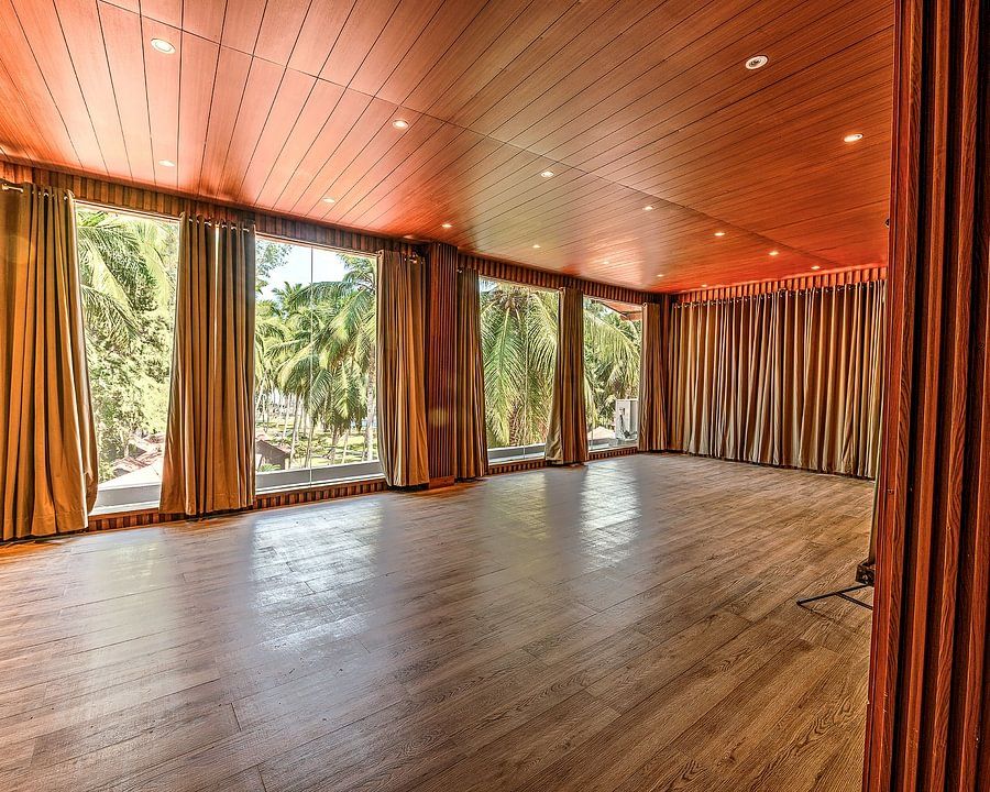 A spacious area with wooden flooring and a pleasant view from the window in the Conference Hall at Silver Sand Beach Resort, Havelock.