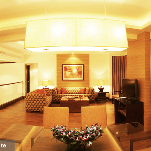 A living room at Presidential Suite at The Retreat Hotel and Convention Centre, with a table,chair, and ambient lights.