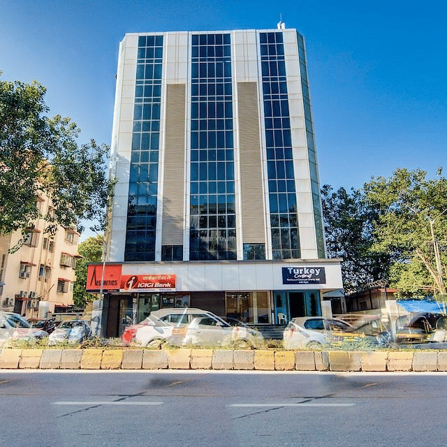 Facade of Mumbai House Hotel, Juhu on a clear, blue day