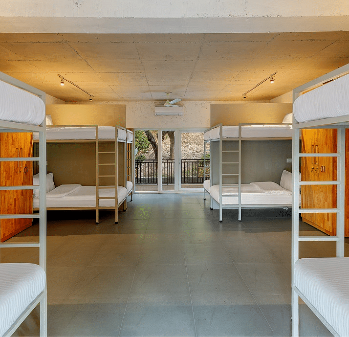 Dorm room with bunk beds and luggage storage.