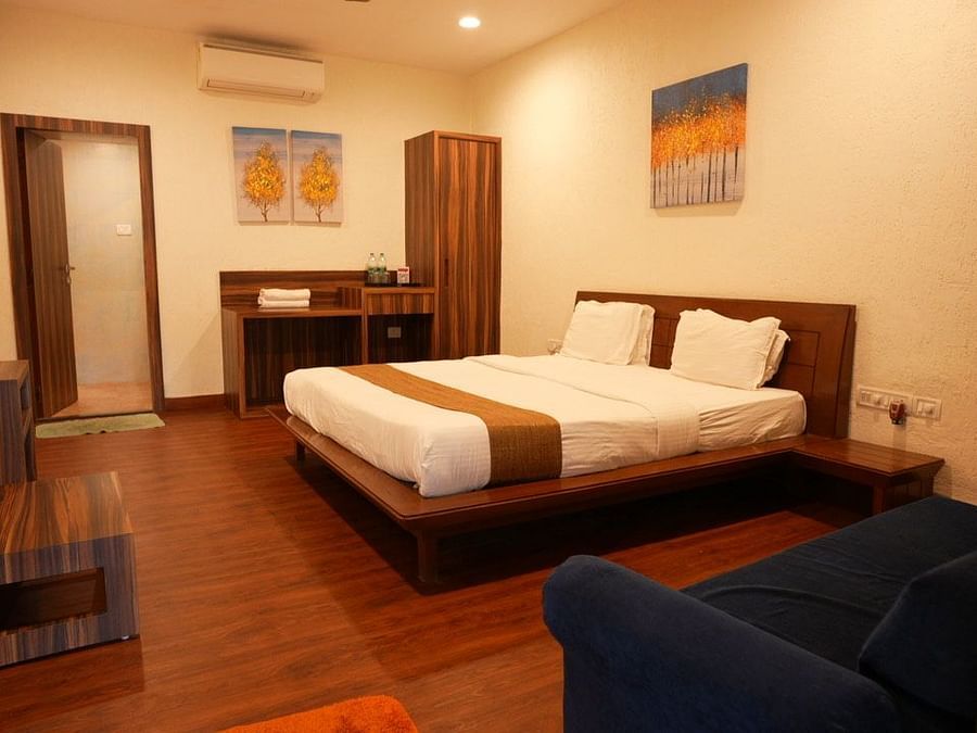 Interior image of Adamo the Village  rooms with a bed, sofa and storage units.