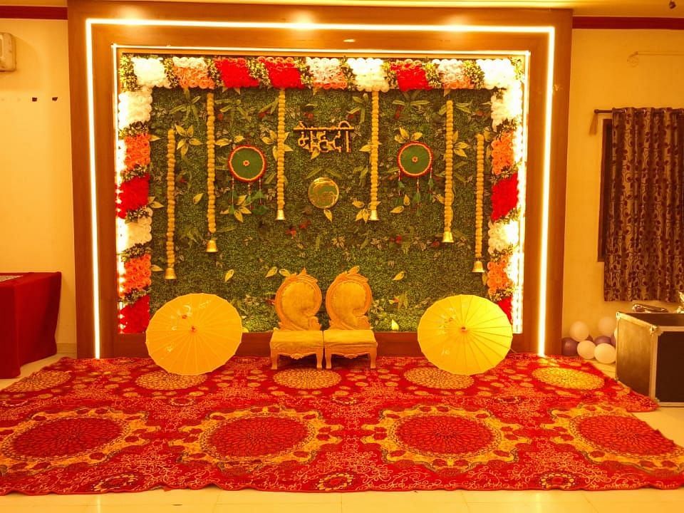 A wedding setup at our event hall in Roorkee with a vibrant floral backdrop - Motel Divine International, Roorkee