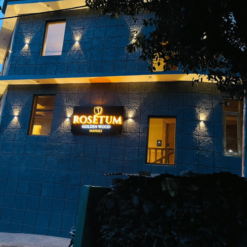 blue painted hotel building captured during dusk - Golden Wood Manali By Rosetum
