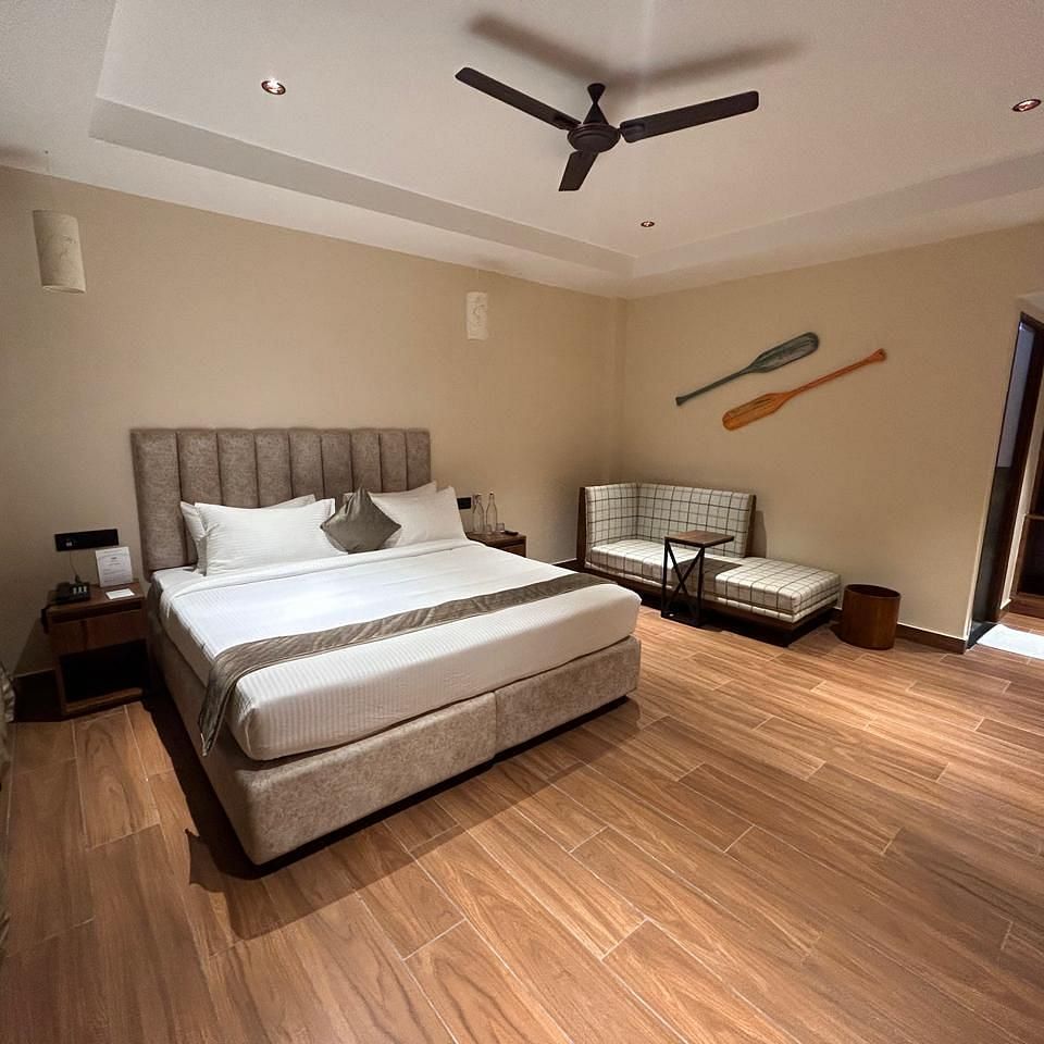 Spacious bedroom featuring a king-sized bed, wooden flooring, and elegant lighting - Arina Island Resort, Swaraj Dweep
