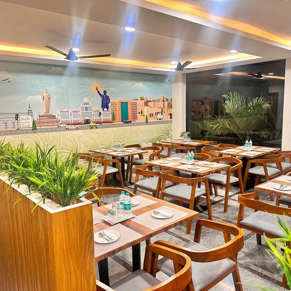 An image of a restaurant where many tables and chairs are arranged | Hotel Aerotel, Hyderabad