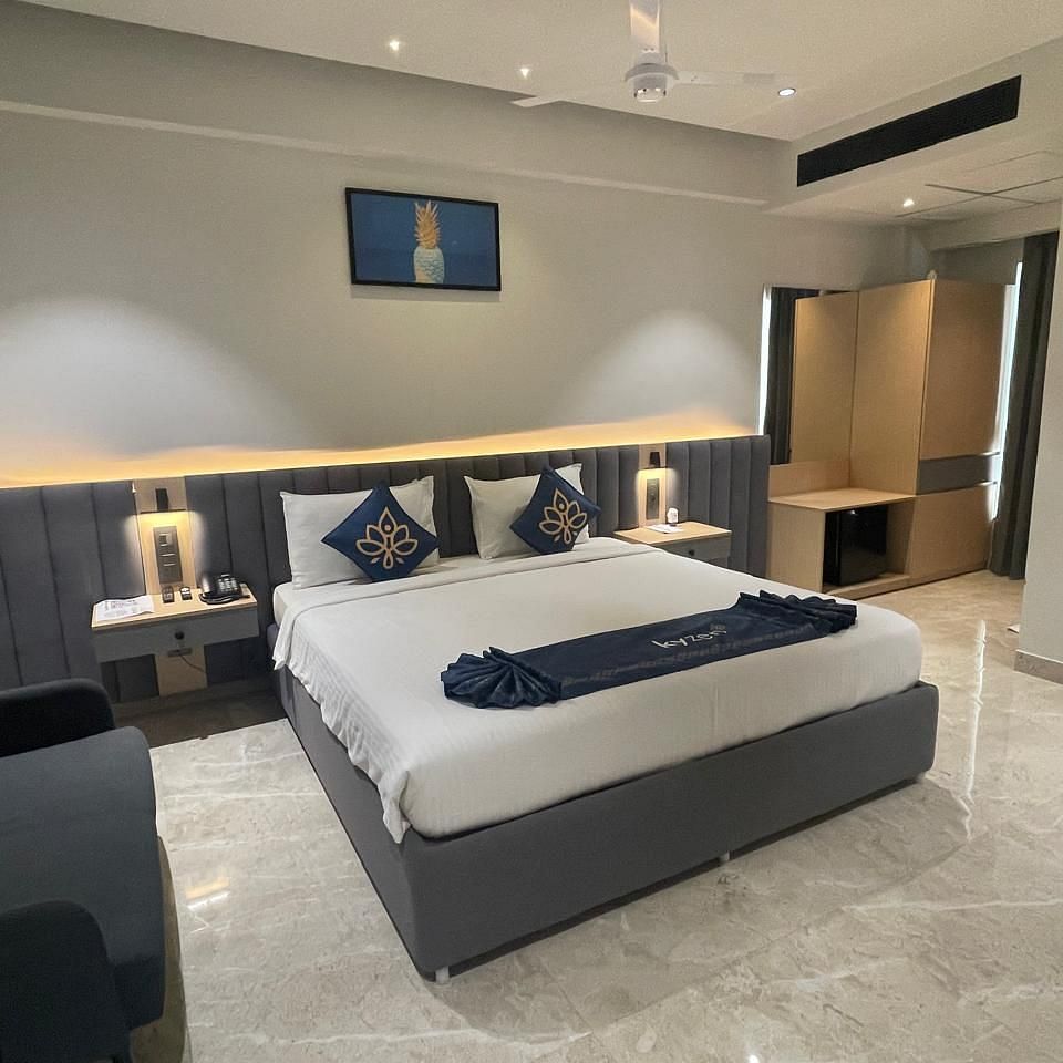 Suite with a large bed, modern bedside lighting, and furnishings at Hotel Kyzen HiTech City – Your Zenly Stay
