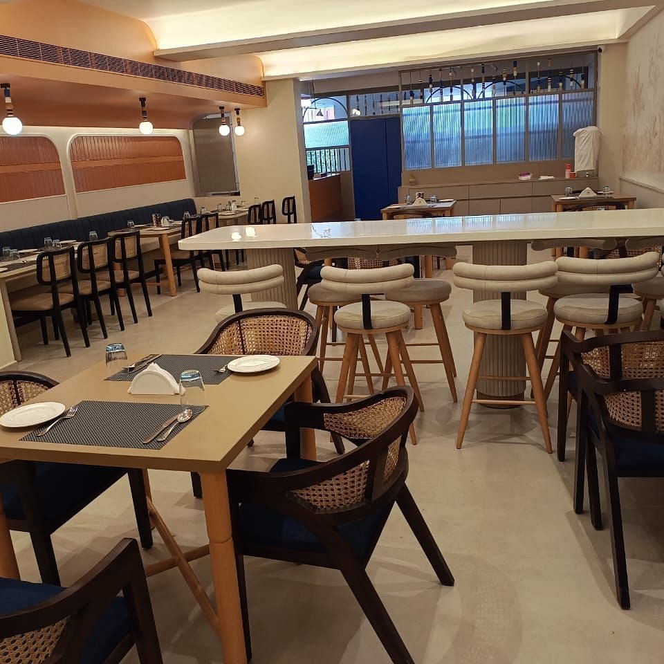 The Manorath restaurant at Lords Eco Inn, Belagavi featuring seating tables in various orientations, warm lighting and a relaxing dining  spot. 