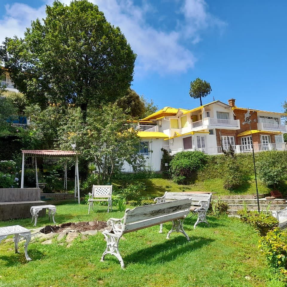 Exterior view of Te Aroha by Shervani Mukteshwar with benches surrounding a fireplace