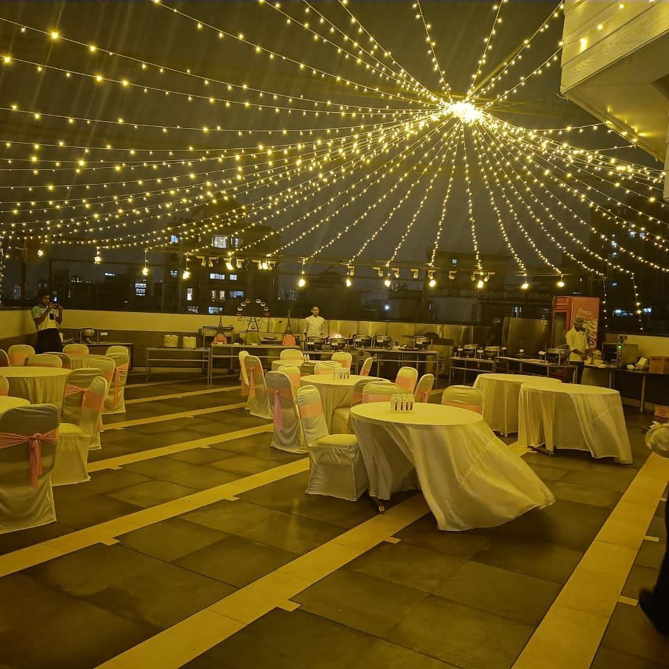Image of an event space at night with chairs and tables and lights hanging from above at The Oriental Residency