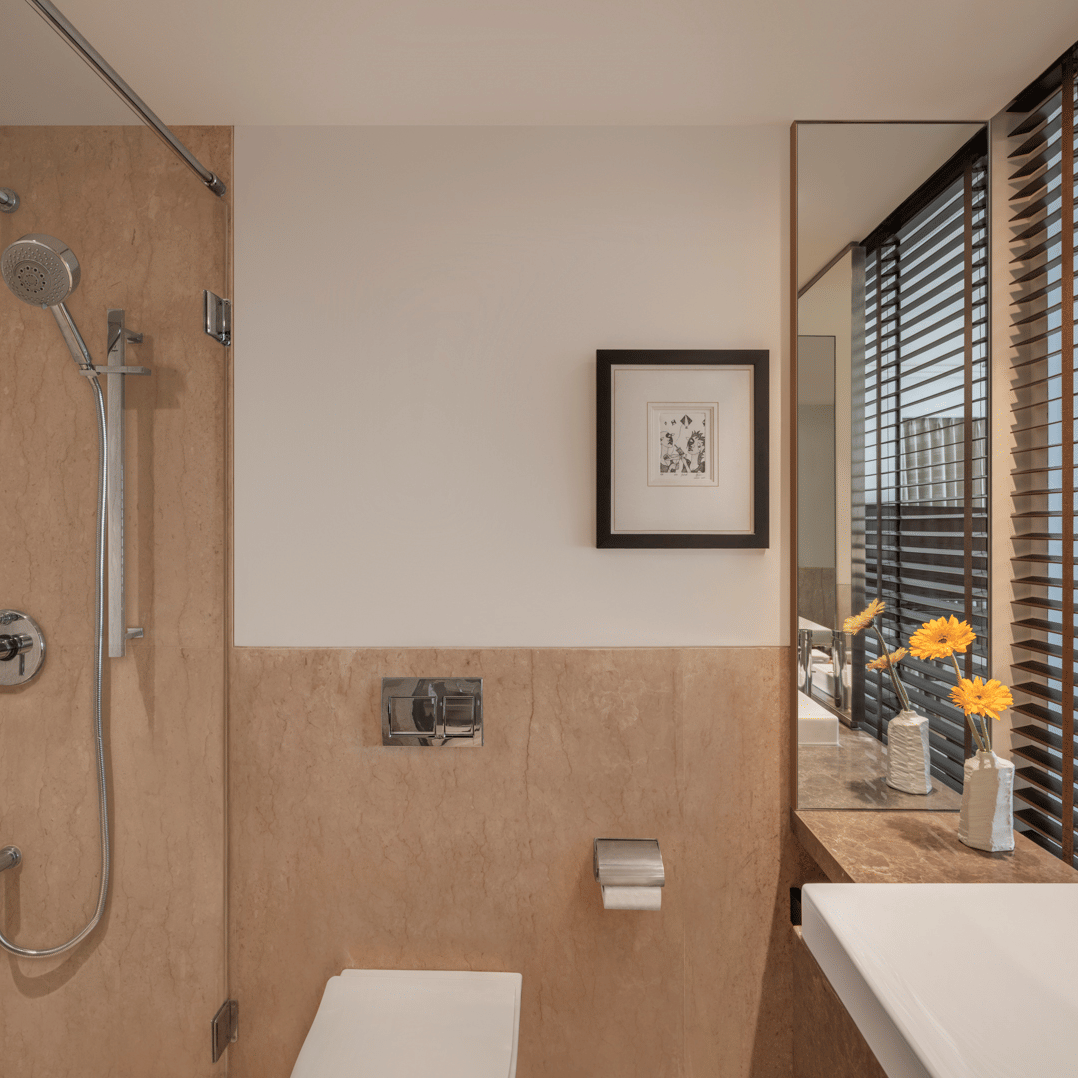 Bathroom with bathtub, sink, and glass divider at The Raintree, St. Mary’s Road.