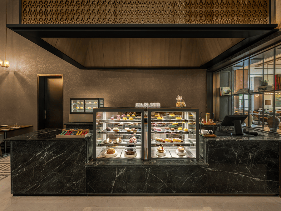 Krave counter with a glass display case and dark toned decor at The Residency Signature Madurai.