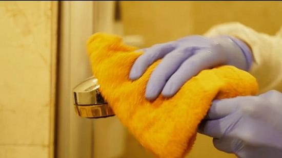 a person wearing a ppe kit and sanitizing the hotel